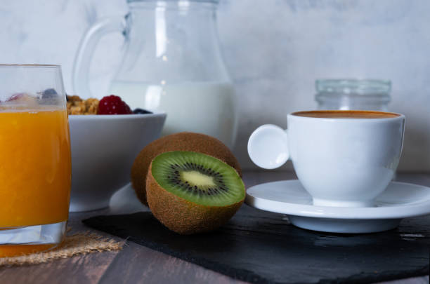 istock Complete breakfast consisting of coffee with milk, orange juice, fresh fruit, cereals and corn bread toast with olive oil on a wooden surface. Healthy concept. 1255264135