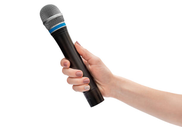 istock Woman's hand holding microphone for singing. Close up. Isolated on white. 1255265408