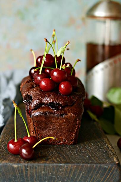 Tasty Chocolate cake (brownie) with cherry on a wooden board.