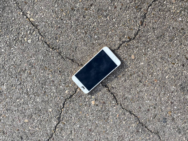 istock Broken cell phone on a cracked road. Concept of technology. 1255268654
