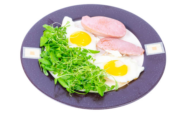 Fried eggs, sausages, fresh green salad, breakfast. Studio Photo