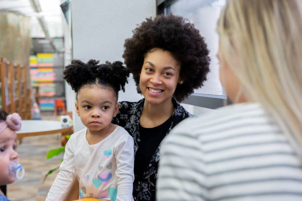 la bella giovane madre e la figlia del bambino si incontrano con gli amici durante il supporto o il gruppo di terapia del gioco - mother new baby nursery foto e immagini stock