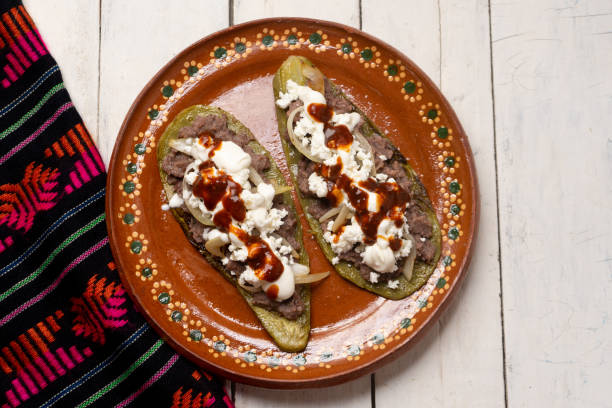 istock Mexican nopal cactus huaraches with cheese and beans on white background 1255271924