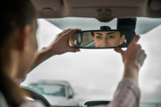 istock Female driver adjusting the rear view mirror in her car 1255273127