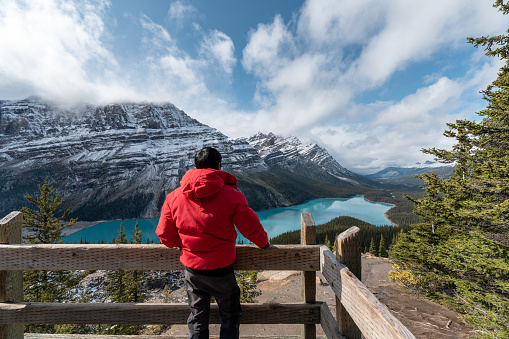 Man wearing winter coat standing and looking the view of Peyto lake at Banff national park, Canada