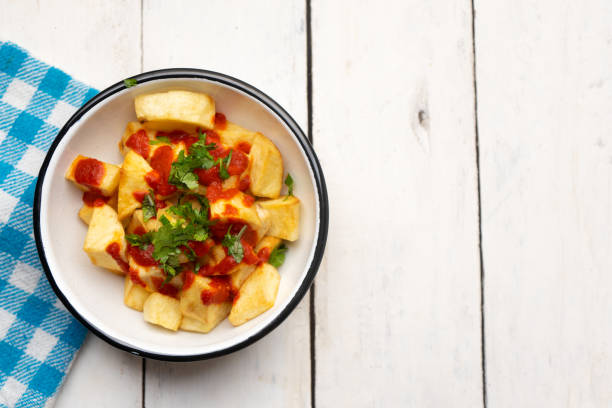 istock Spanish fried potatoes with willow also called potatoes bravas on white background 1255274686