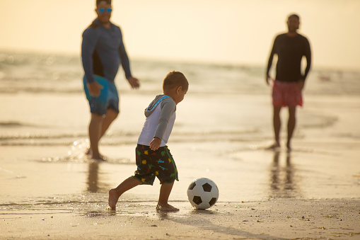 People playing soccer on the beach