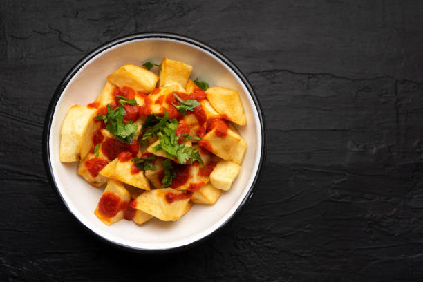 istock Spanish fried potatoes with willow also called potatoes bravas on dark background 1255275054