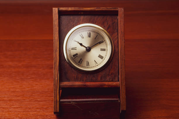 istock Retro wooden clock. square shaped vintage clock with round dial. wood table 1255275785