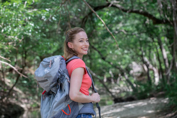 istock Woman who is hiking and wearing a hiking backpack 1255278003