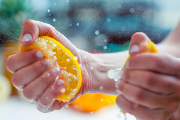 istock Woman squeezing the juice from a lemon. 1255285451