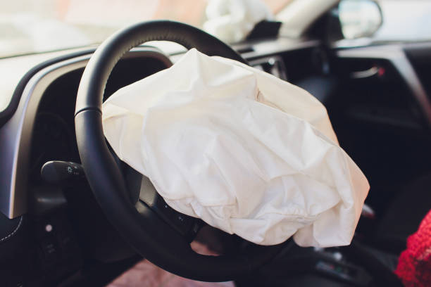 Interior of a automobile or car involved in a vehicle crash with a deployed steering column airbag. stock photo