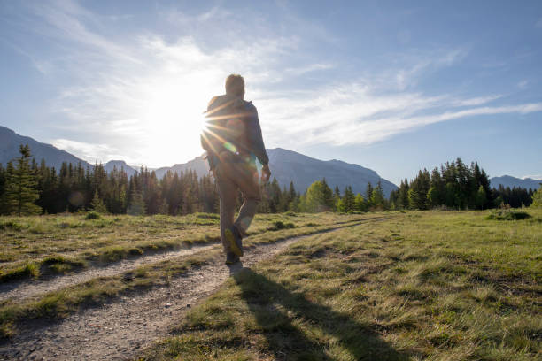 istock Hiker walks through grassy meadow in the morning 1255287030