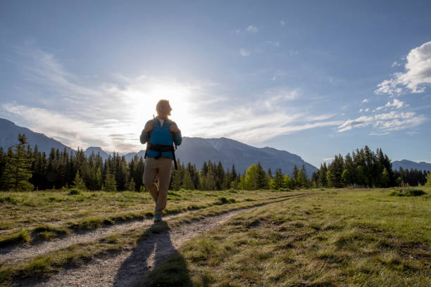 istock Hiker walks through grassy meadow in the morning 1255287360