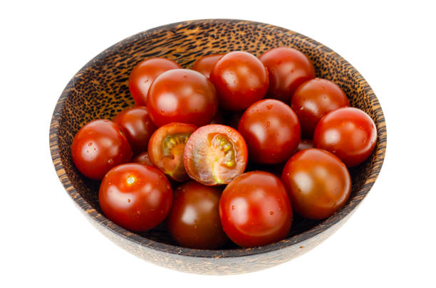 istock Small red and black cherry tomatoes isolated 1255288780