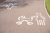 Sign mom with a stroller drawn by white paint on the road in the park.