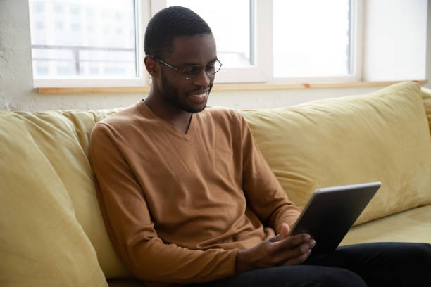 istock Smiling African American man holding and using tablet. 1255292033