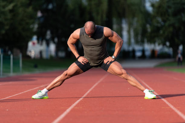 istock Young Fitness Man Runner Stretching Legs Before Run 1255292280