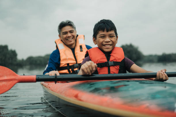 istock Asian father and son kayaking at river 1255302163