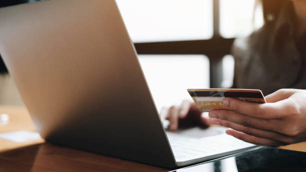 istock woman's hands holding smartphone and using credit card for online shopping. 1255302869