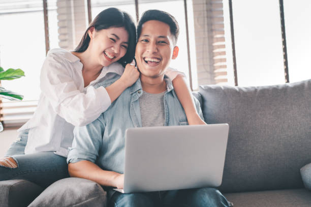 istock happy Asian couple having a good time at home 1255311050