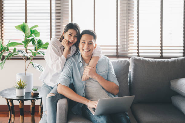 istock happy Asian couple having a good time at home 1255311073