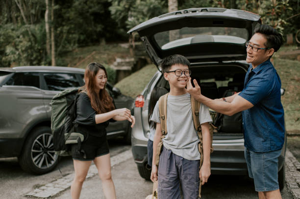 una famiglia cinese asiatica che si prepara per l'escursionismo dall'area del parcheggio - malaysian person family asian ethnicity mother foto e immagini stock