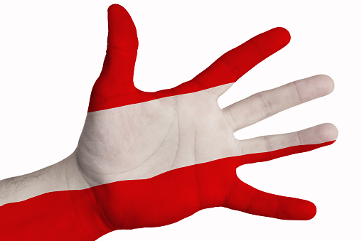 A man showing the flag of Austria in the palm of his hand. Image on a white background