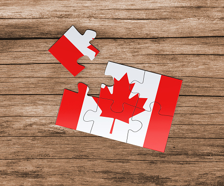 Canada national flag on jigsaw puzzle. One piece is missing. Danger concept.