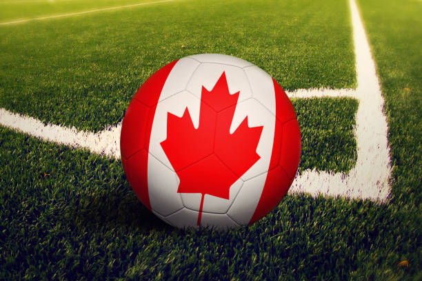 bandera de canadá en la pelota en la posición de tiro de esquina, fondo de campo de fútbol. tema de fútbol nacional sobre hierba verde. - canadian football fotografías e imágenes de stock