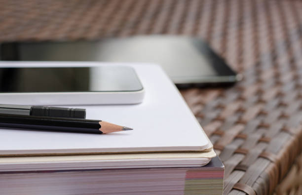 istock Black pencil and phone on books 1255330635