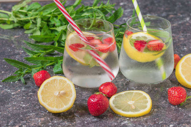 istock Two glass glasses with ice water with berries and lemon. 1255330898
