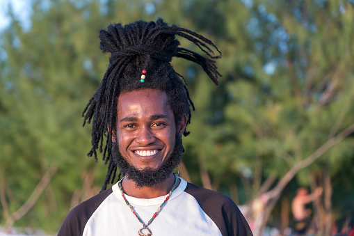 Zanzibar, Tanzania - december 31, 2019 : African joyful man with dreadlocks on his head on a tropical beach on the island of Zanzibar, Tanzania, east Africa, close up
