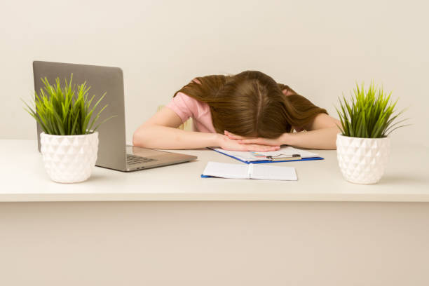 istock Tired overworked young intern woman working with a laptop in an office 1255342000