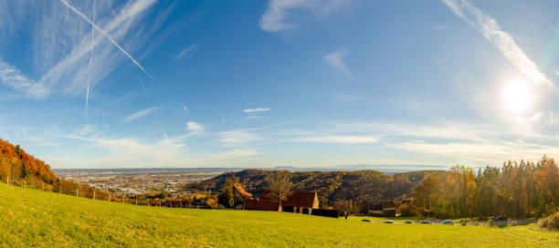 Panorama from hill near Graz in styria. Autumn view on City scape forests and meadow. Blue clear sky with small clouds and sun shinning