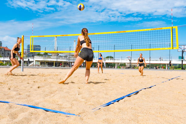 mädchen spielen beachvolleyball - strand volleyball stock-fotos und bilder