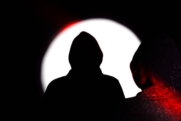 istock Man in hoodie. Shadow in the spotlight. 1255347996