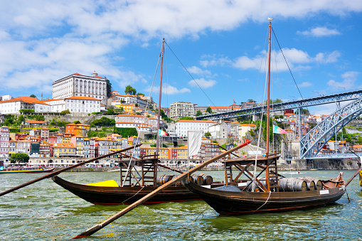 Rabelo boats on the Douro river and Dom Luis I bridge in Porto, Portugal. Composite photo