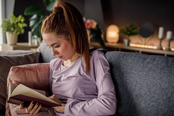 istock Young woman studying from a book she is reading 1255352127