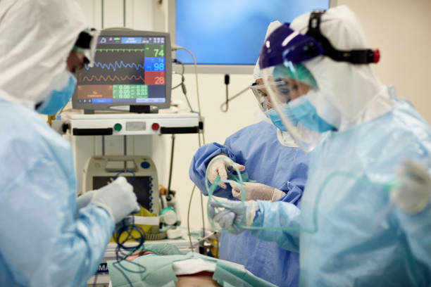 istock Surgical Team in Full Protective Gear Preparing to Operate 1255356839