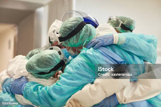 Doctors And Nurses With Arms Around Each Other In Support Stock Photo - Download Image Now
