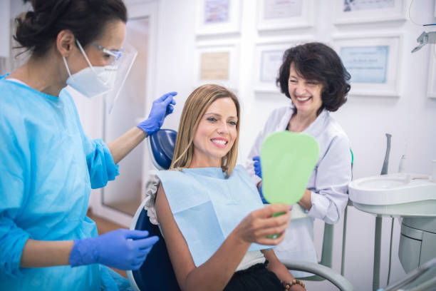 istock Satisfied Female Patient Checking Her Teeth After Treatment. 1255358617