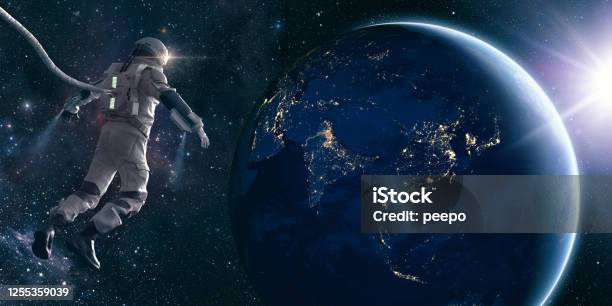 Astronaut On Space Walk Looks At Lights Of Planet Earth Stock Photo - Download Image Now