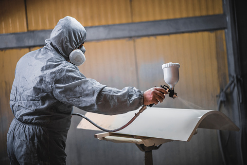 Protective Paint Spraying Of Furniture Parts By Worker