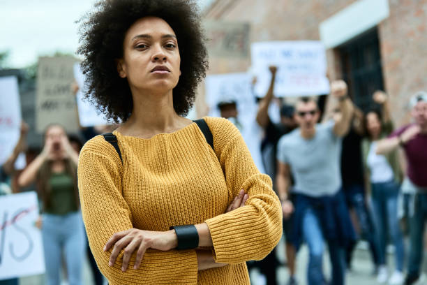 I am the same as all of you! Young confident black woman with crossed arms taking a part in a protest for human rights. police brutality photos stock pictures, royalty-free photos & images