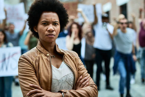 portrait of displeased black woman with crossed arms on a protest for human rights. - anti racism imagens e fotografias de stock