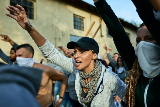 istock Angry female activist shouting while participating in public demonstrations. 1255362436