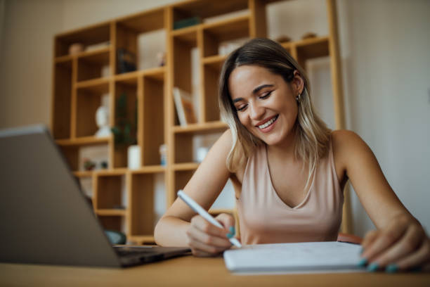 istock Cheerful young businesswoman taking notes, portrait. 1255362574