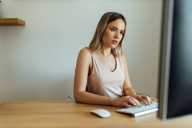 istock Focused beautiful young woman working on computer, portrait. 1255362577