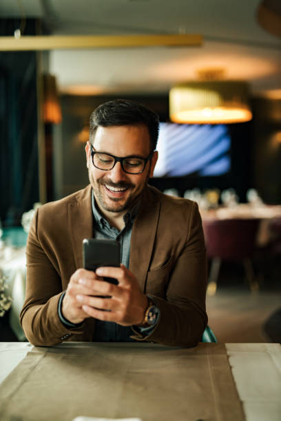 istock Happy man using smart phone at restaurant, portrait. 1255362615